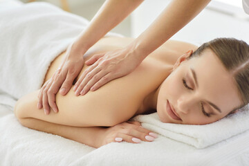 Masseur conducts spa procedure with back massage for client in salon, offering luxury therapy and body care for relaxation in a professional setting with focus on wellness and treatment.