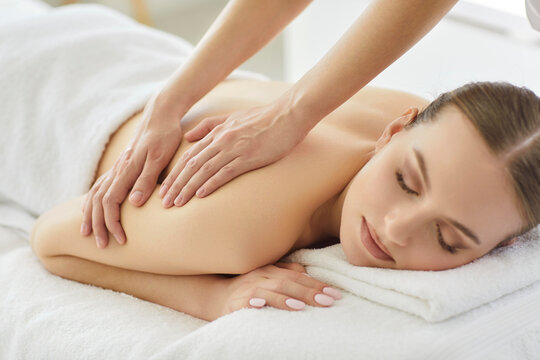 Masseur conducts spa procedure with back massage for client in salon, offering luxury therapy and body care for relaxation in a professional setting with focus on wellness and treatment.
