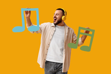 Young man in headphones with paper music notes singing on yellow background