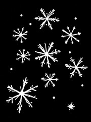 A pattern of white doodle snowflakes on a solid black background. This high-contrast winter design has a whimsical, festive look perfect for holiday and seasonal projects.