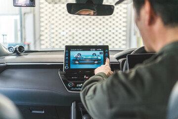 Male auto mechanic using a tablet device inside a car
