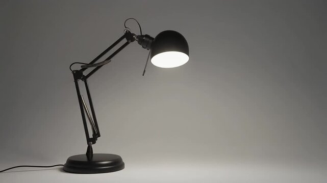 Stylish adjustable desk lamp rotating smoothly in a dark room, perfect for studying or working late, providing focused light and modern aesthetic