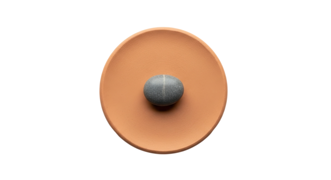 A single round grey stone sits perfectly centered in a rustic earthenware bowl, creating a serene and minimalist still life with earthy tones and textures