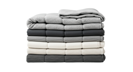 A neat stack of folded cozy blankets in various shades of gray and white, showcasing different soft textures like waffle knit for a comfortable and warm home interior decor