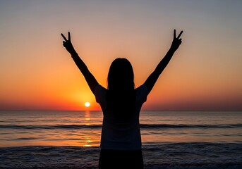 Fototapeta premium Woman silhouetted at beach celebrates with peace signs during sunset.