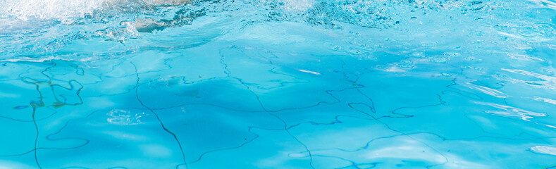 Blue swimming pool water creating ripples and splash