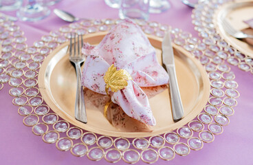 Elegant table setting with gold charger and floral napkin