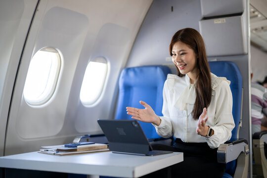 Businesswoman making video call on airplane while flying