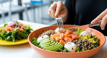 Woman enjoying a healthy salad with salmon, avocado, and quinoa for a nutritious meal