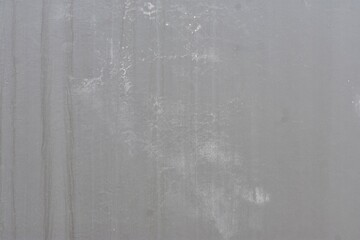 A close-up shot of a smooth grey concrete wall with subtle texture and stains.