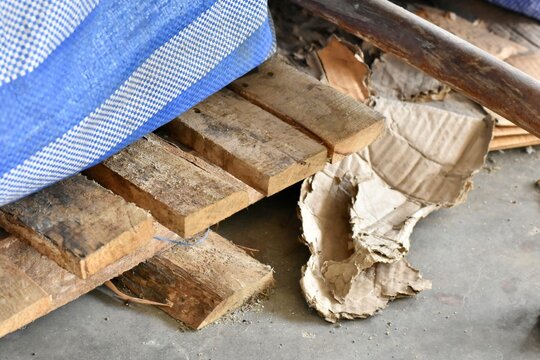 Broken wooden pallet with torn white sack fabric, presenting a rough industrial and storage environment.