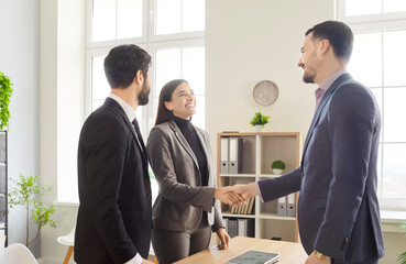 Handshake of business people on meeting to celebrate agreement, negotiation of partners in office. Happy man and woman shake hands with smile and trust, professional support. Partnership concept