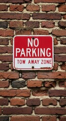 Obraz premium Aged sign warning against parking in a tow away zone fixed on a brick wall surface
