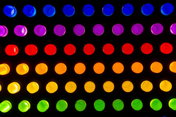 Centered grid of glowing neon circles arranged in rainbow rows on a dark background. Bright, symmetrical abstract pattern ideal for tech design, pride themes, creative marketing, and modern digital ar