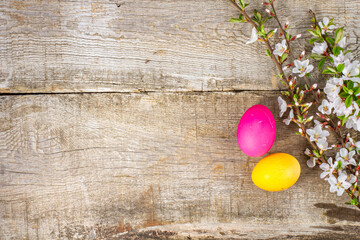 Colorful Easter eggs and blooming flowers on rustic wooden background celebrate spring and holiday joy in a cheerful setting
