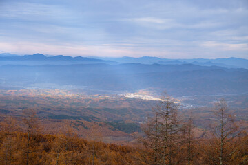 日本：山並みをバックに雲間から太陽光が射す町／長野県小海町・ふるさとの森付近から撮影・11月