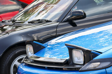 Nostalgic blue sports car with classic design and pop up headlight. This automotive vehicle at show...