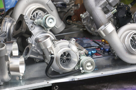 Close up view of car engine turbocharger part, powerful automotive metal component for performance tuning in workshop, showcasing precision engineering and raw power