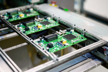 Electronic circuit boards moving along an assembly line at a manufacturing facility during daytime operations