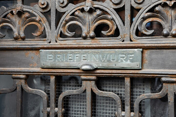 Briefeinwurf (mail slot) at an old building in Germany. Forged steel at an ancient house exterior. Architectural feature at an entrance door.