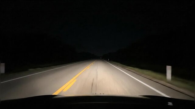 Night driving on a rural highway illuminated by car headlights showing the road ahead - Powered by Adobe