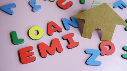 Naklejka premium Home made with paper and EMI with letters shows concept of buying home with loan or EMI.