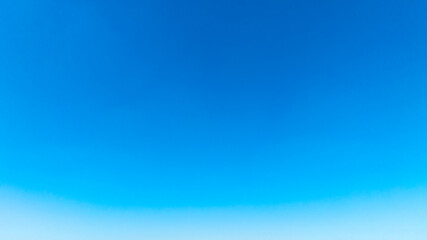 A bright, clear blue sky meets a glowing white horizon, suggesting a serene, open, and with sunlight of beautiful cloudy sky. landscape or abstract background.	

