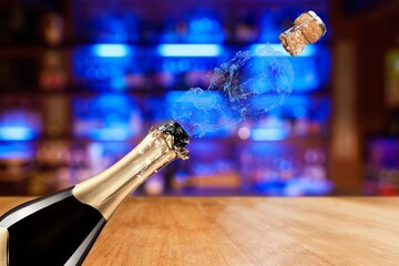 Obraz premium A champagne bottle popping its cork, with bubbles and spray emerging, symbolizing celebration and joy in a festive atmosphere