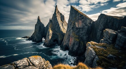 Dramatic coastal landscape with jagged cliffs meeting the turbulent ocean under a cloudy sky
