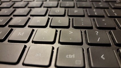 Close up view of black laptop keyboard keys showing letters and symbols