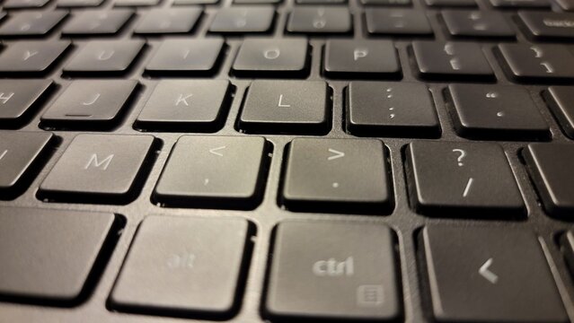 Close up view of black laptop keyboard keys showing letters and symbols