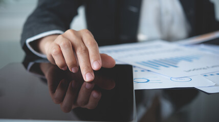 Business analyst using digital tablet analyzing financial statement, business report for audit internal control system. Businesswoman working with business documents at office. 