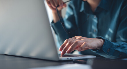 Close up of business woman working on laptop computer and thinking of problem solution, searching the ideas, market research, business technology concept