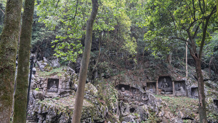 An ancient Chinese temple. The sculptures are carved from stone in mossy stones. Statues and scenes...