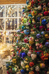 Beautiful festive decorations on the Christmas tree. Close-up. Beautiful Christmas background. The concept of decorations and decor for the new year. New Year's Card