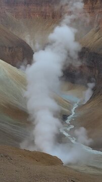 Steam from a Deep Canyon. Rising Wall of Endless Smoke/Steam Loop. A panoramic view of an immense, dry canyon. A column of heavy, moist white steam rises from the canyon floor.
