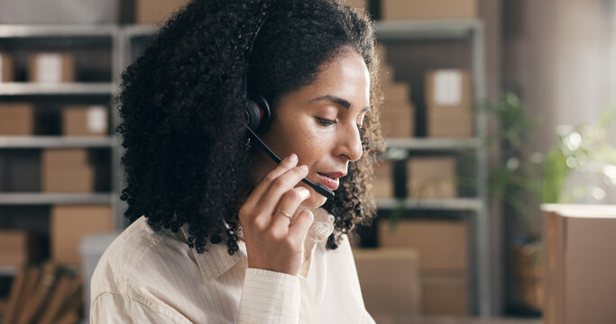 Small business, woman and talking on headset in logistics for pricing enquiry, shipping FAQ and help. Supply chain, agent and speaking to client in warehouse for delivery status and order processing