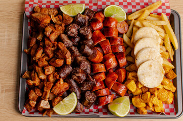 Colombian meat platter with sausages, chicharrón and fries