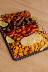 Colombian meat platter with sausages, chicharrón and fries
