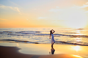 Fototapeta premium 夕焼けの海を眺める彼女