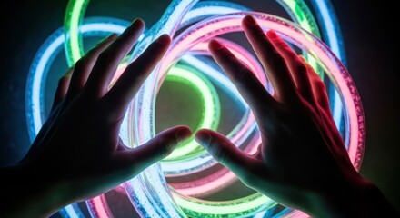 Close-up shot of two hands interacting with colorful neon light trails in a dark room with a mesmerizing and futuristic mood.