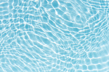 Blue water with ripples on the surface. Defocus blurred transparent blue colored clear calm water surface texture with splashes and bubbles. Water waves with shining pattern texture background.