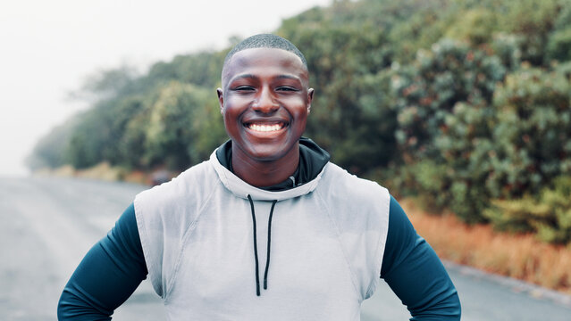 Nature, fitness and portrait of black man on road, marathon runner and ready for cardio training. Outdoor, morning mist and confident athlete smile for endurance practice, wellness or start workout