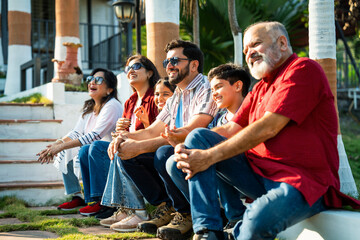 Indian family enjoying outdoor bonding time on steps during weekend relaxation