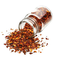 Red pepper flakes spill from a tilted clear glass jar onto a dark background, creating a vibrant, textured scattering of dried chili pieces
