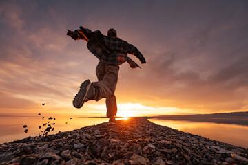 Young happy woman girl runs at sunset lake shore. Vacations near the water concept