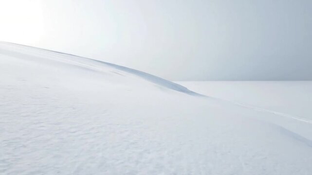 A solitary, snow covered hill crest, gently sloped, against a soft, overcast winter sky, emphasizing vastness and quietude. Wide shot, static or slow pan
