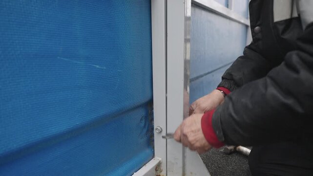 A man tightens a nut with a wrench