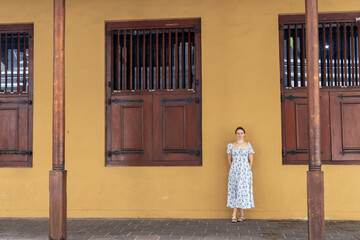 Young woman standing by a colonial-era building in the Dutch Hospital precinct, Colombo, Sri Lanka