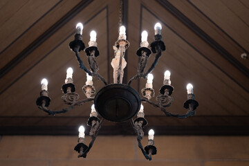 Ornate chandelier glows warmly with multiple candle-shaped bulbs, creating timeless